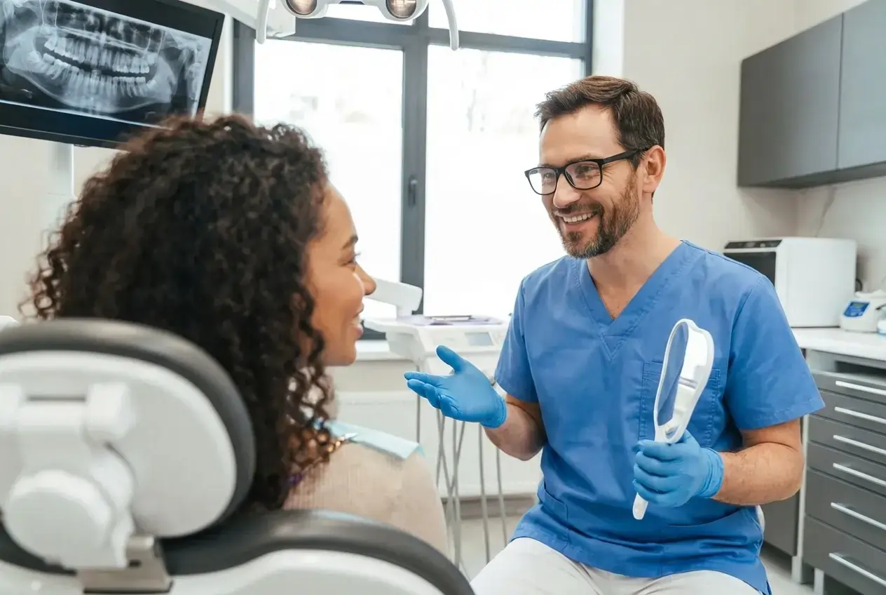 Stomatolog razgovara s pacijentom tijekom pregleda zubi u modernoj ordinaciji