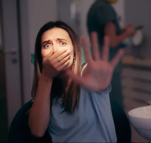 Pacientka na zobozdravstvenem stolu se boji zobozdravnika.